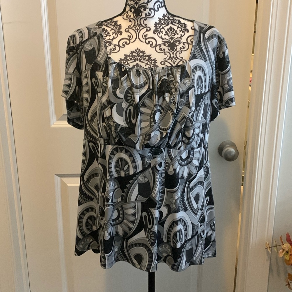 Woman’s short sleeve top in black and grey with geometric pattern.